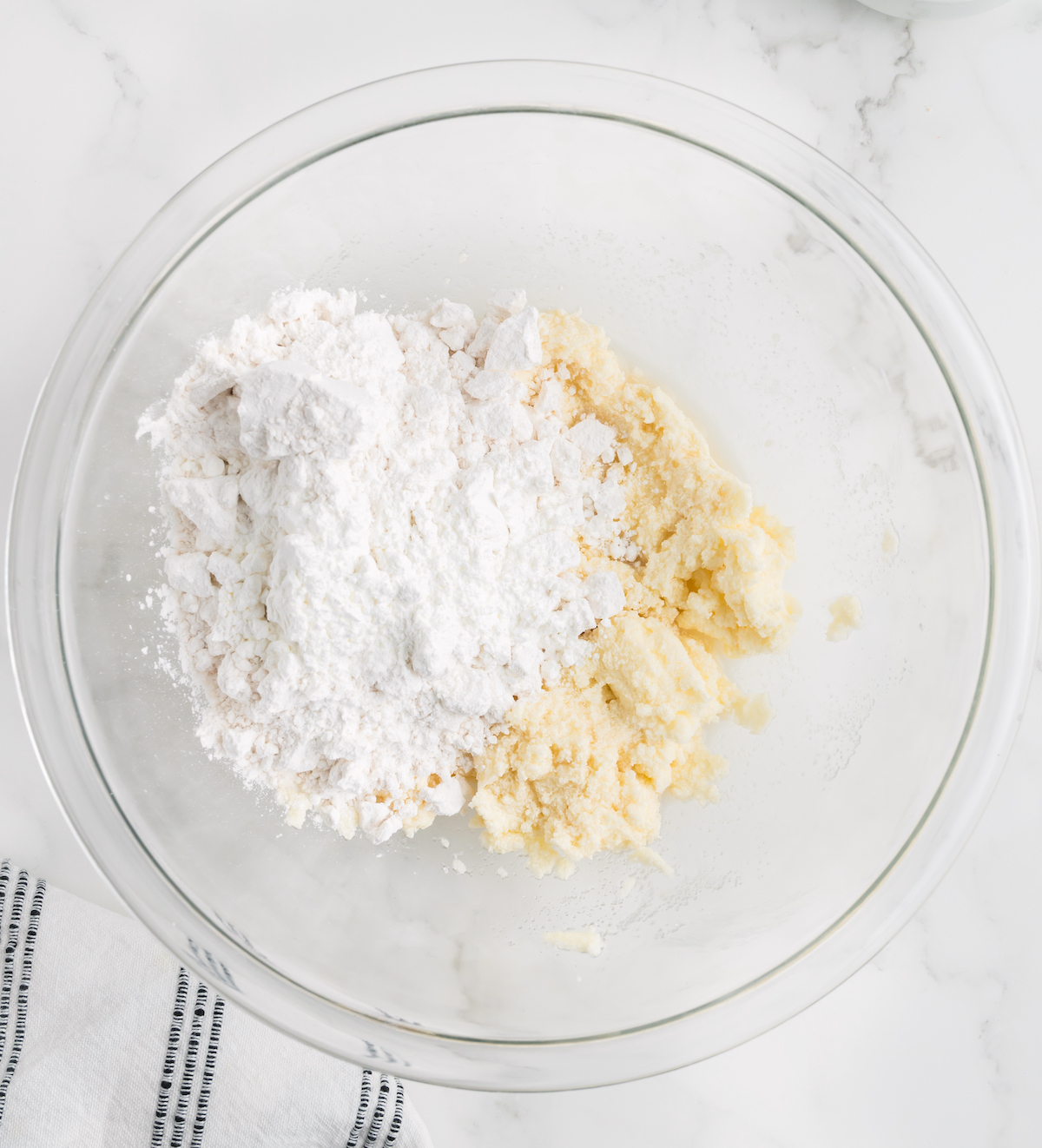 Flour and cornstarch being added to creamed butter and sugar
