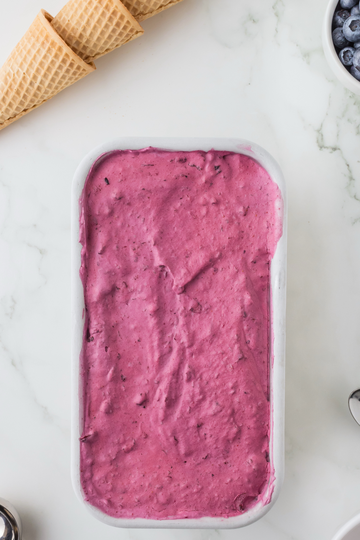 Frozen blueberry ice cream thawing on the counter