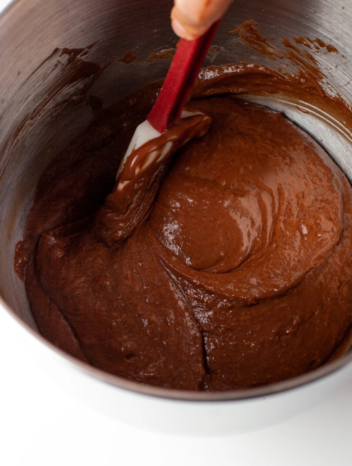 Scraping chocolate batter off the sides of a mixing bowl