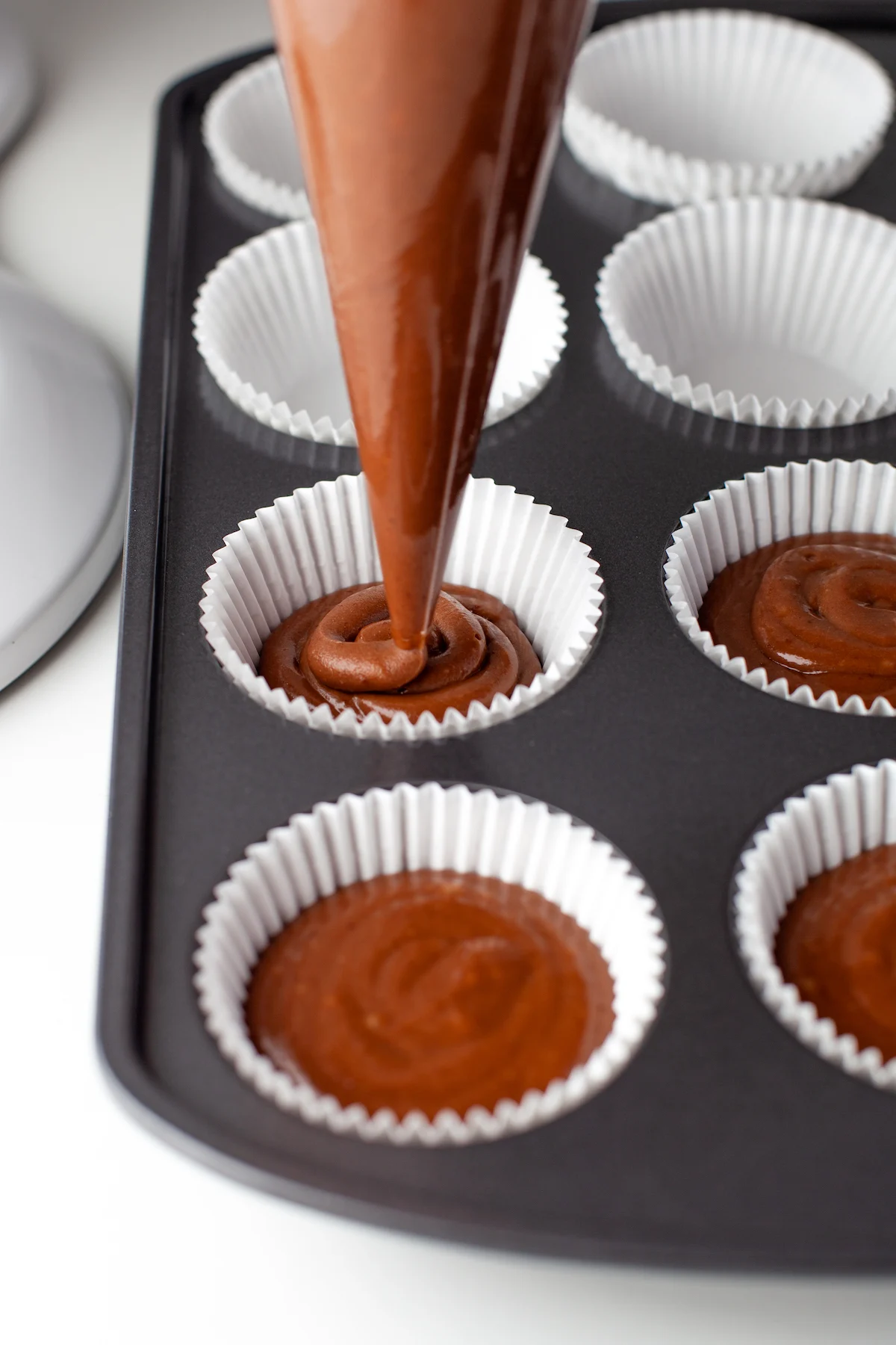 chocolate cupcake batter being put into liners