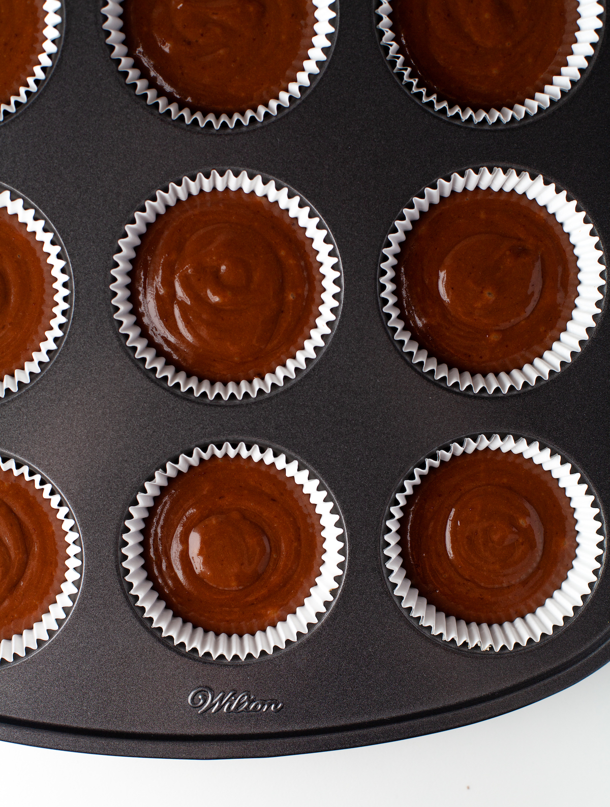 chocolate cupcake batter in a muffin tin