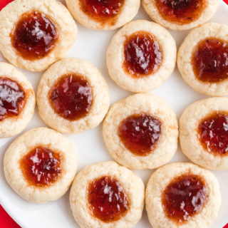 cookies with jam in the middle on a white plate