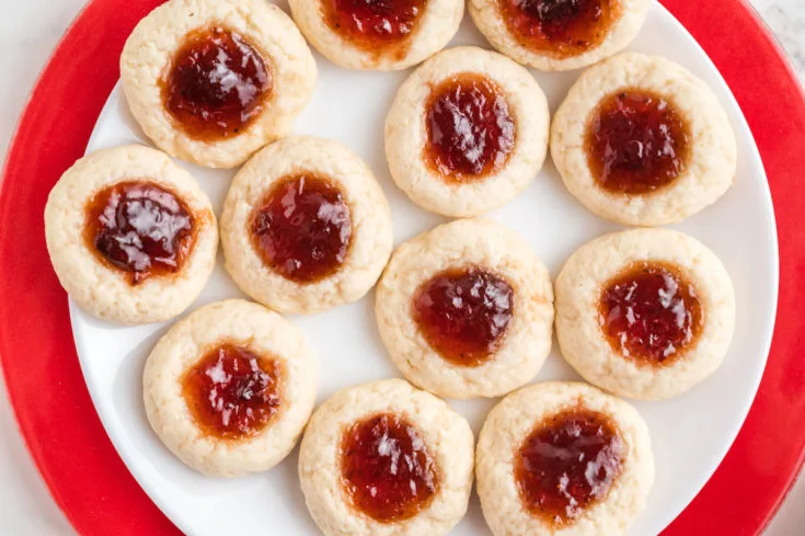 cookies with jam in the middle on a white plate