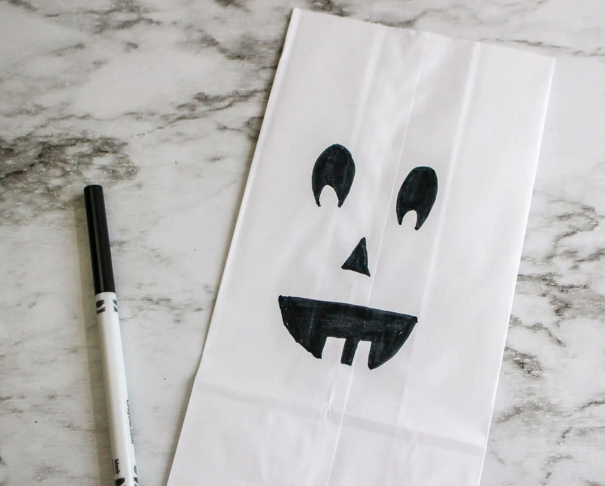 jack o lantern face drawn on a paper bag