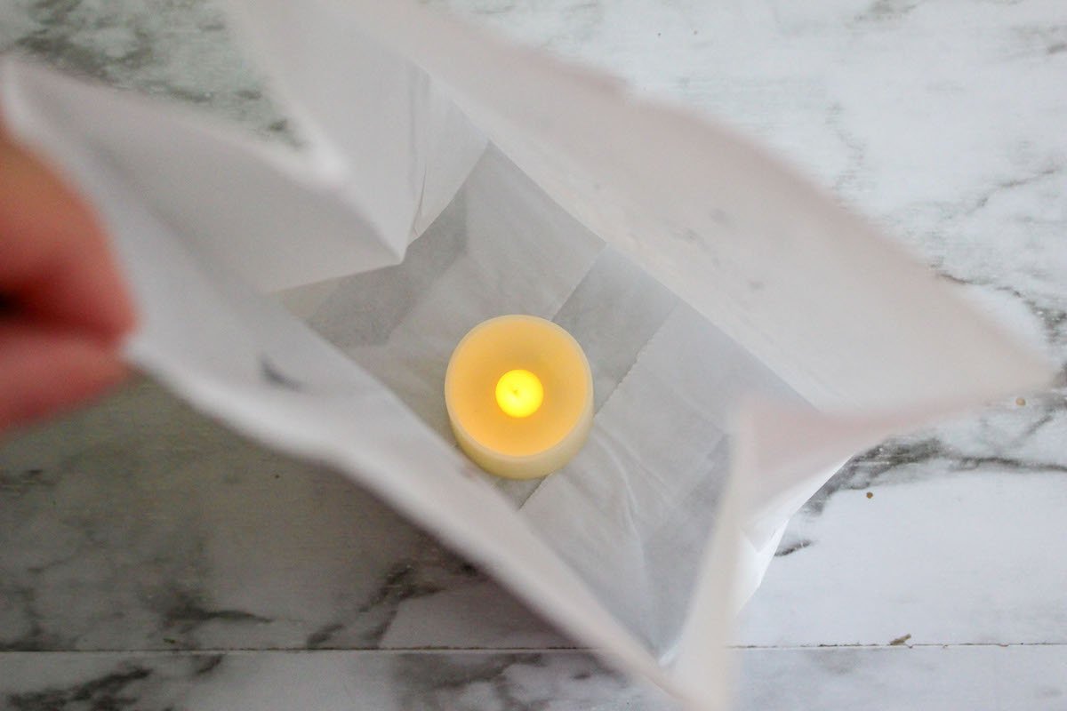 luminary down inside a white paper bag