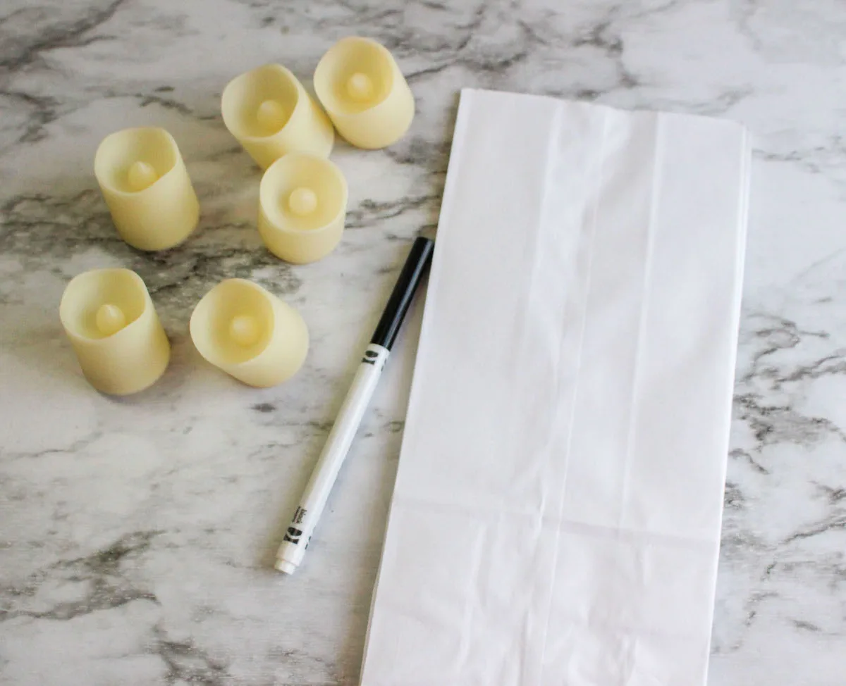 votive candles, black marker, and a white paper bag