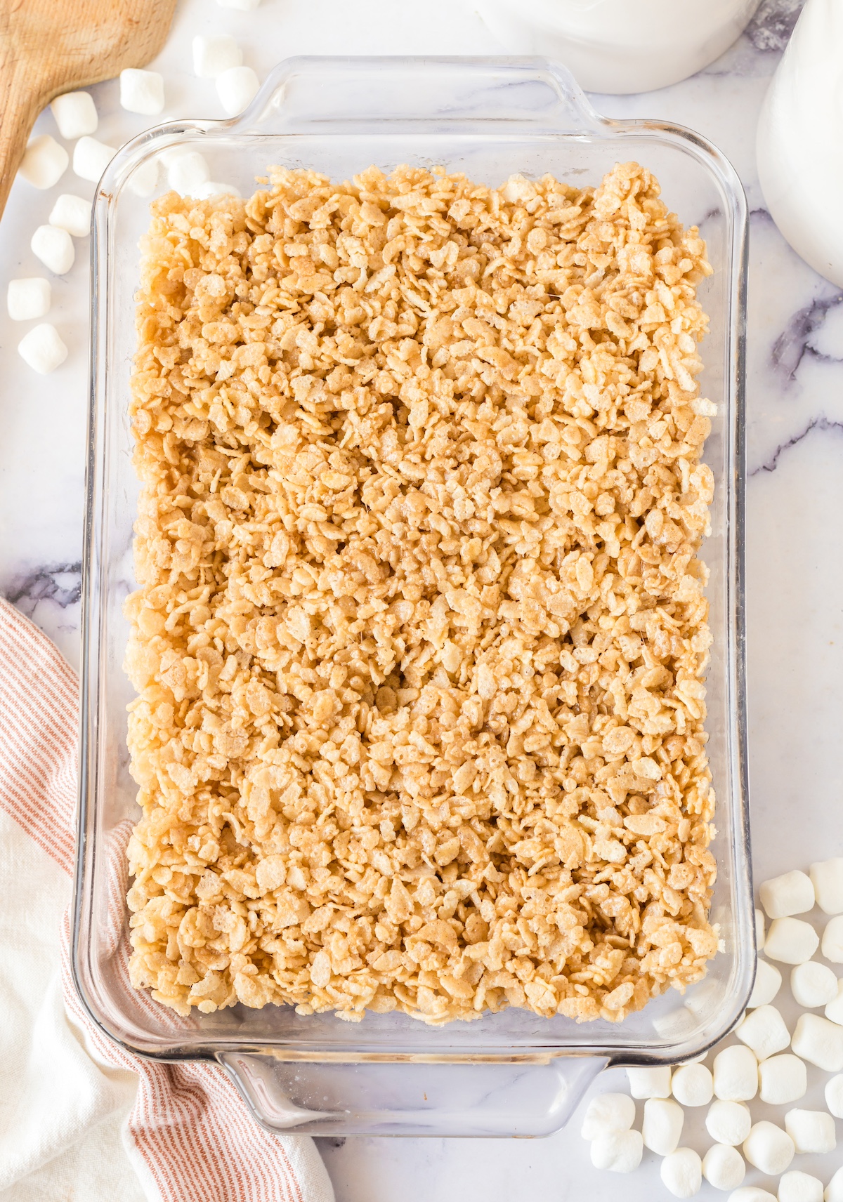 Cereal and marshmallow mixture spread into a glass pan