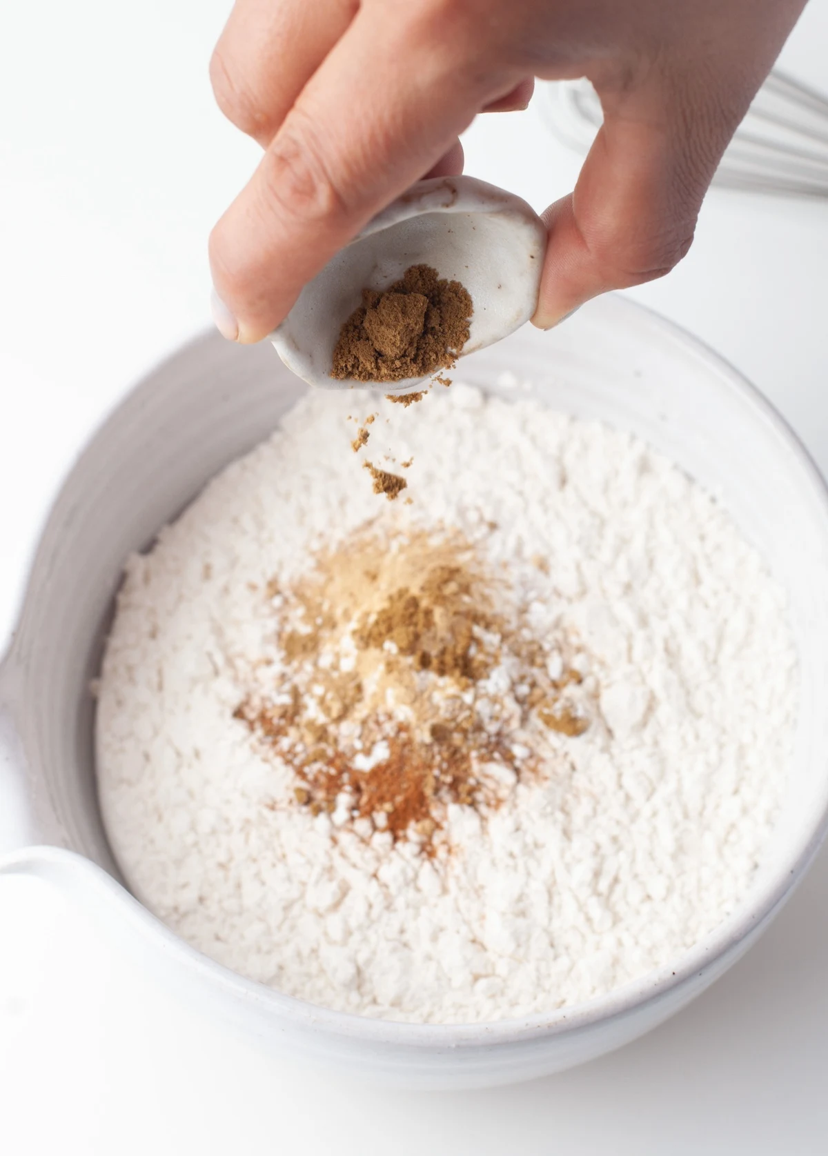 Combining flour, baking powder, baking soda, cinnamon, ginger, nutmeg, and salt in a medium bowl
