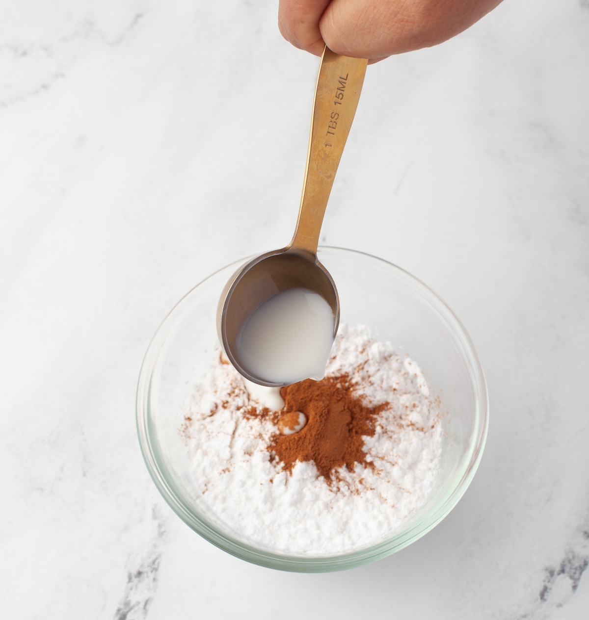 Combining the confectioners sugar with cinnamon and cream in a small bowl