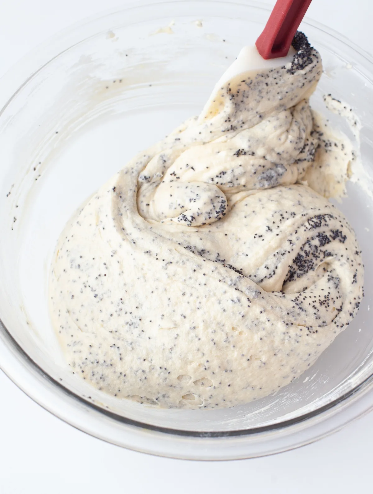 Folding the poppy seeds into the batter with a spatula