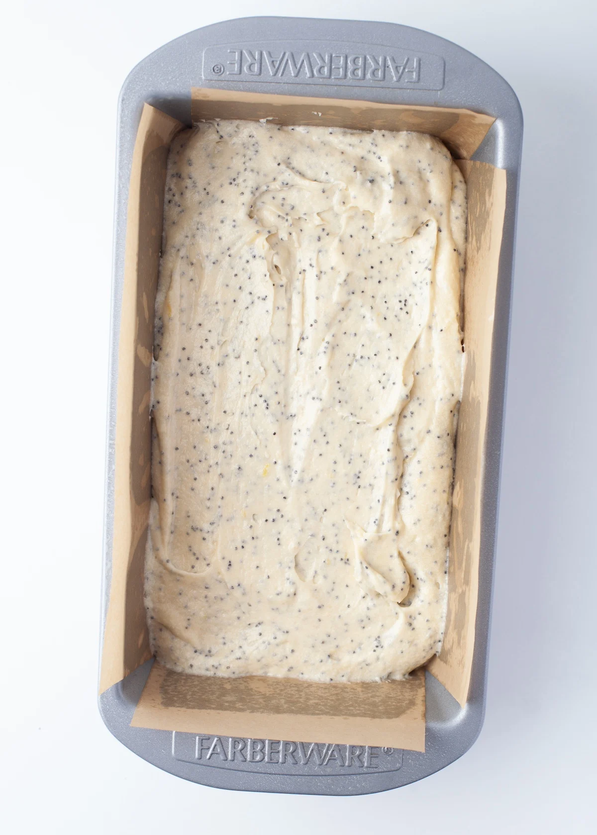 Lemon poppy seed batter added to a loaf pan