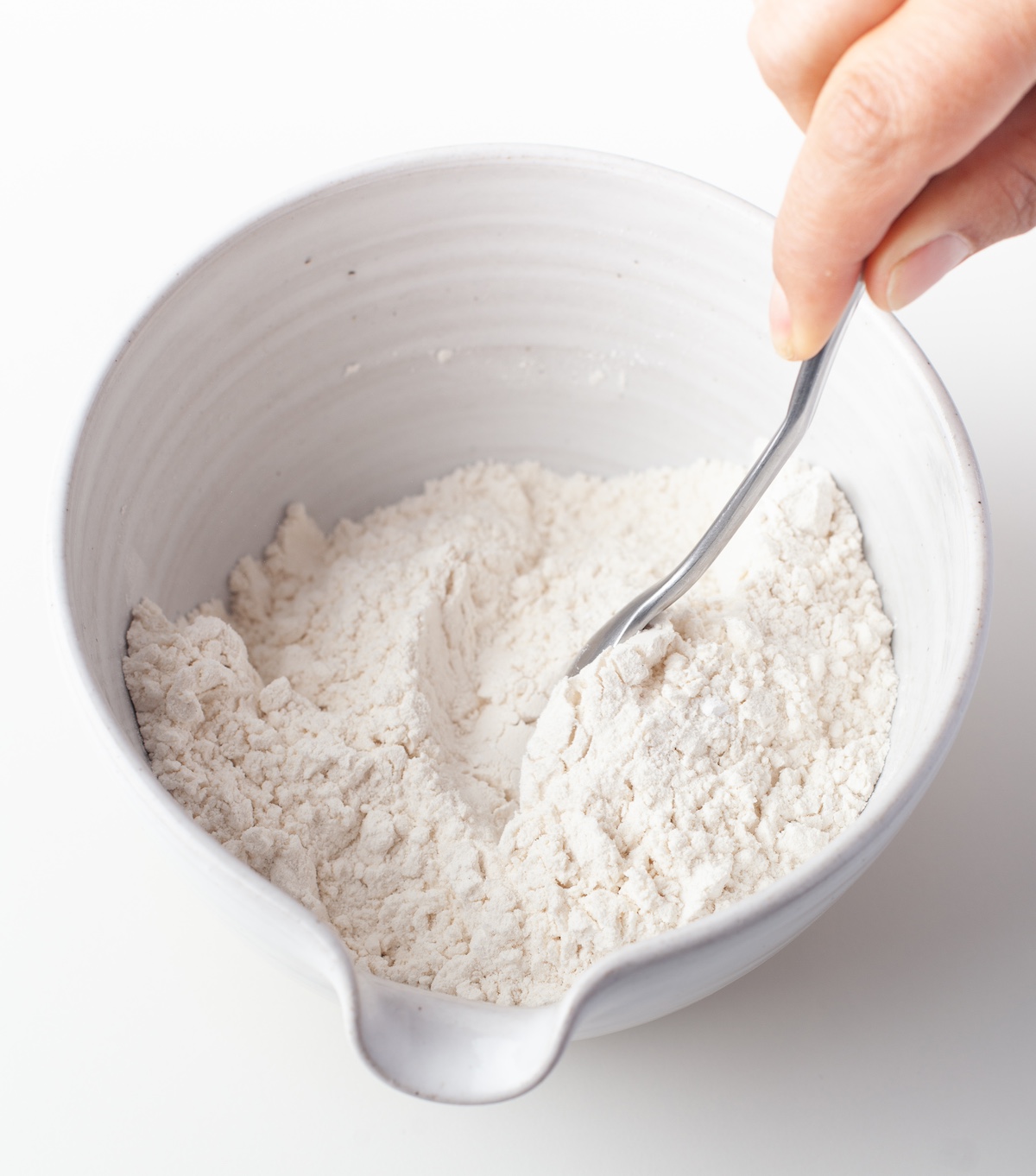 Whisking together dry ingredients in a ceramic bowl