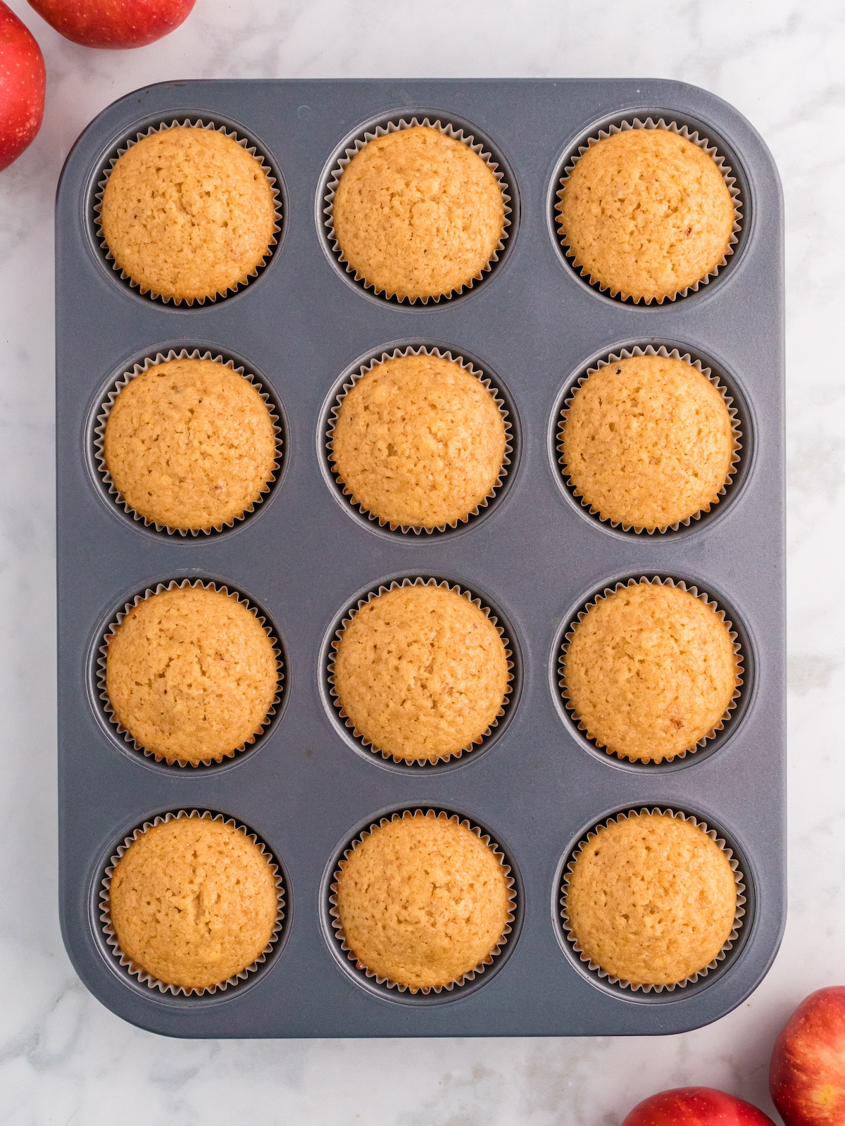 Baked apple cider muffins in a tin