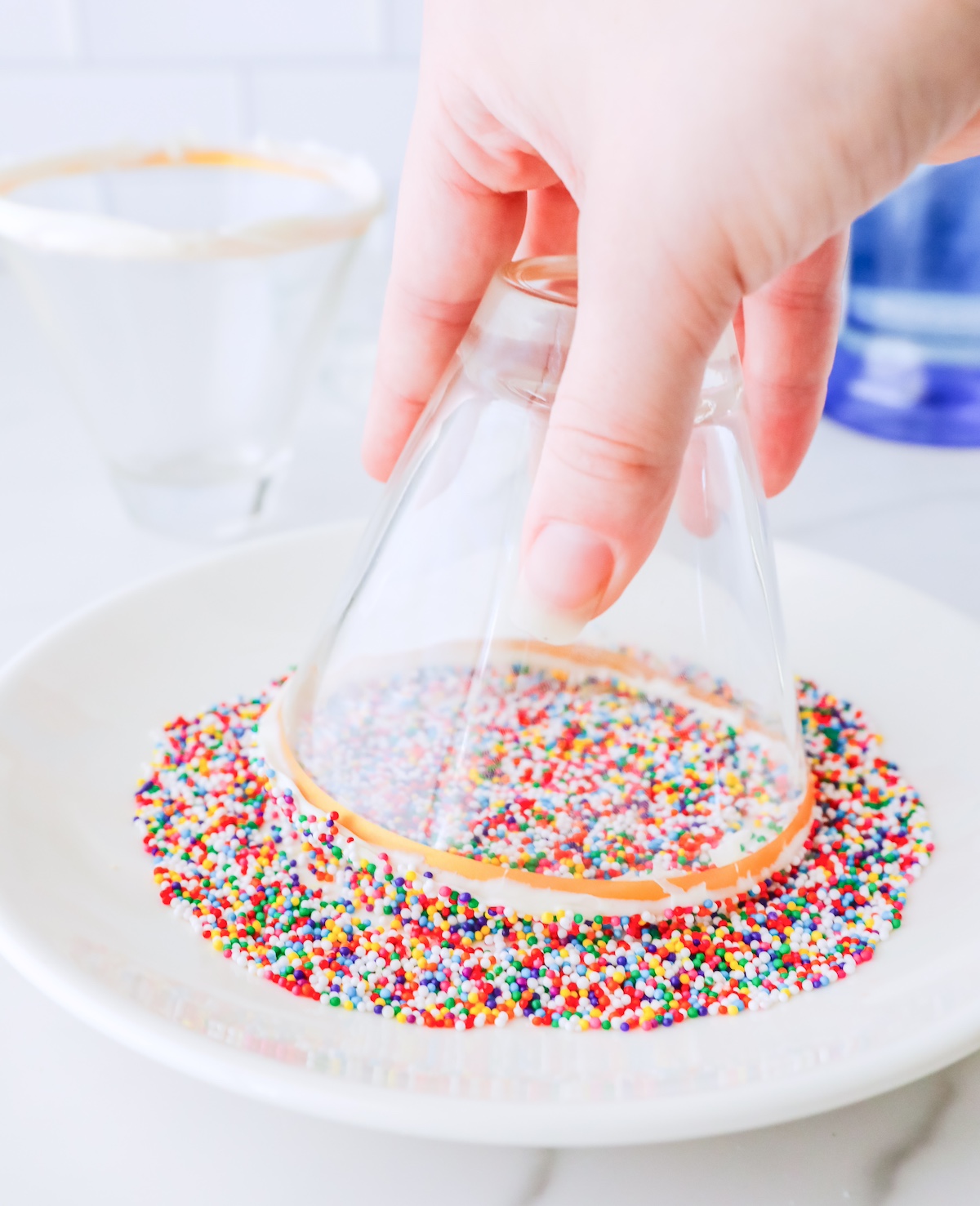 Dipping the cup with icing in rainbow sprinkles