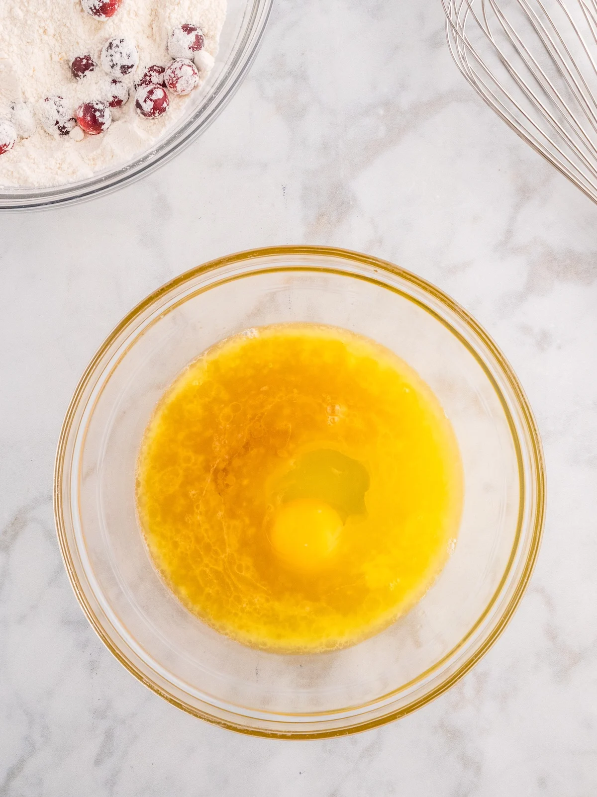 Glass bowl with freshly squeezed orange juice, melted butter, egg, and vanilla extract