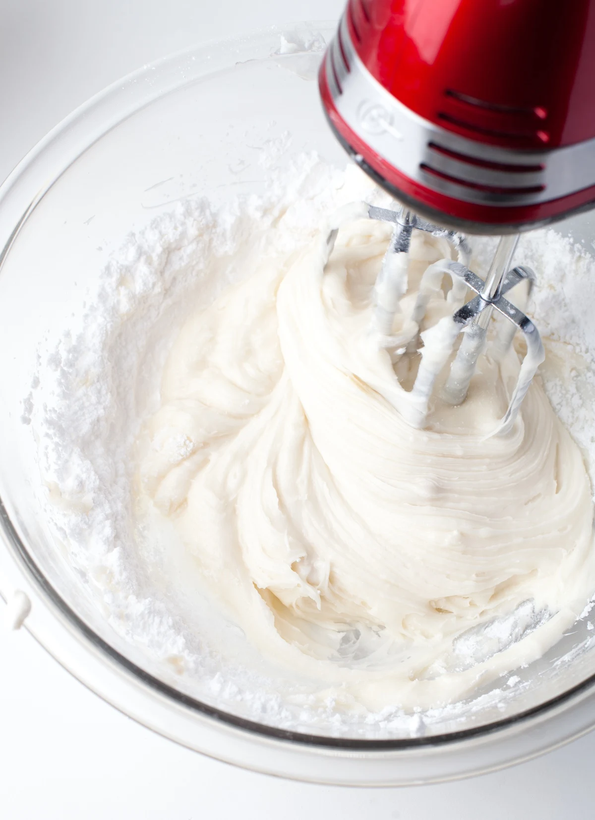 Mixer blending powdered sugar into the butter and cream cheese