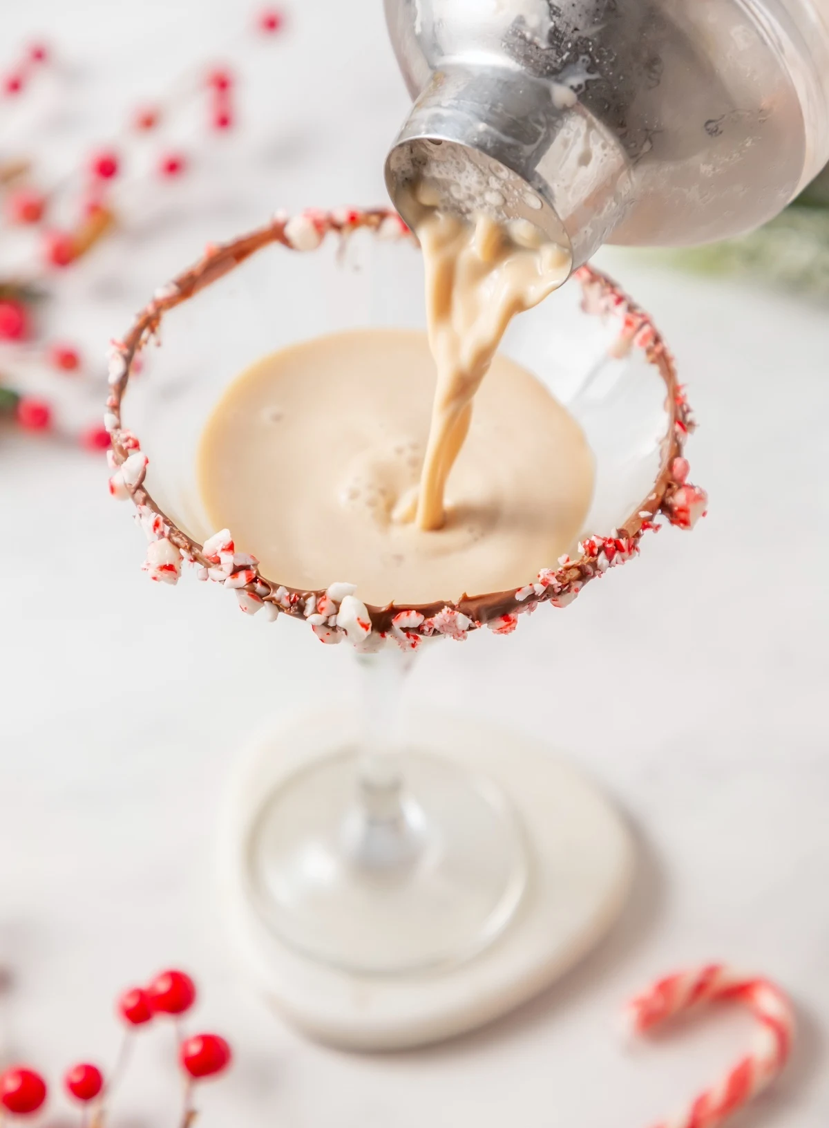 Pouring the candy cane martini into the prepared glass
