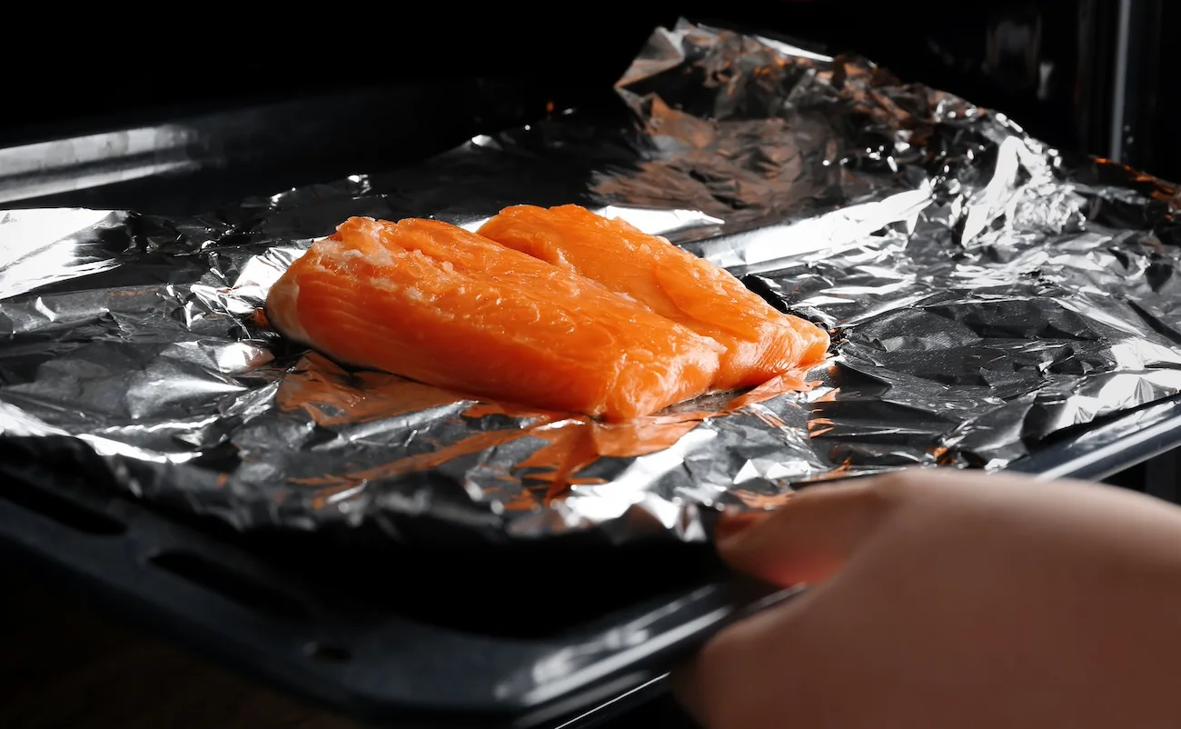 Putting-raw-salmon-into-the-oven-to-bake