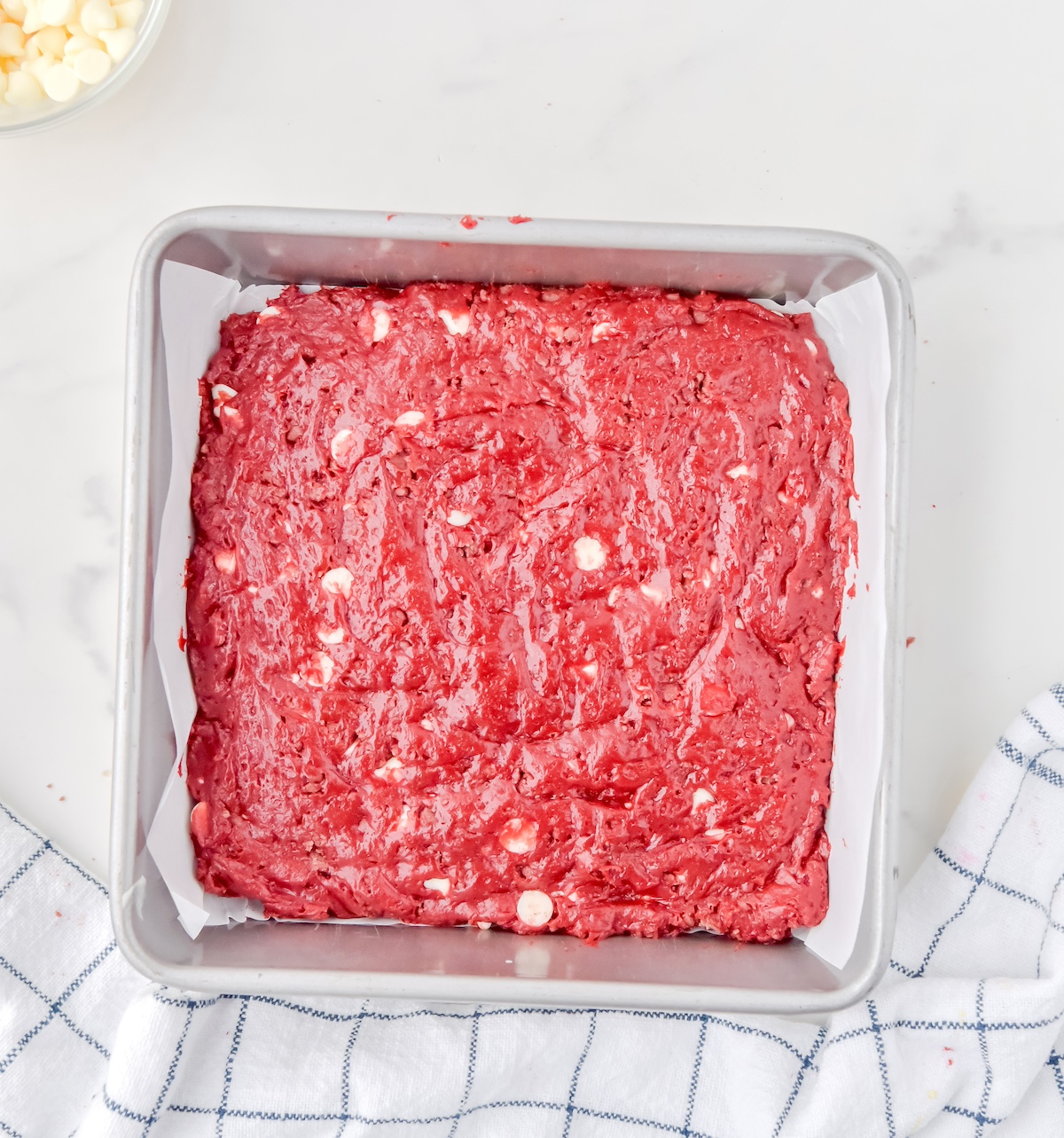 Red velvet batter spread out in a square pan