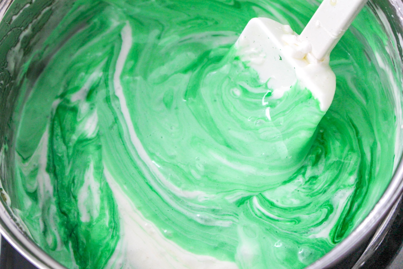 Dying the marshmallows with green food coloring