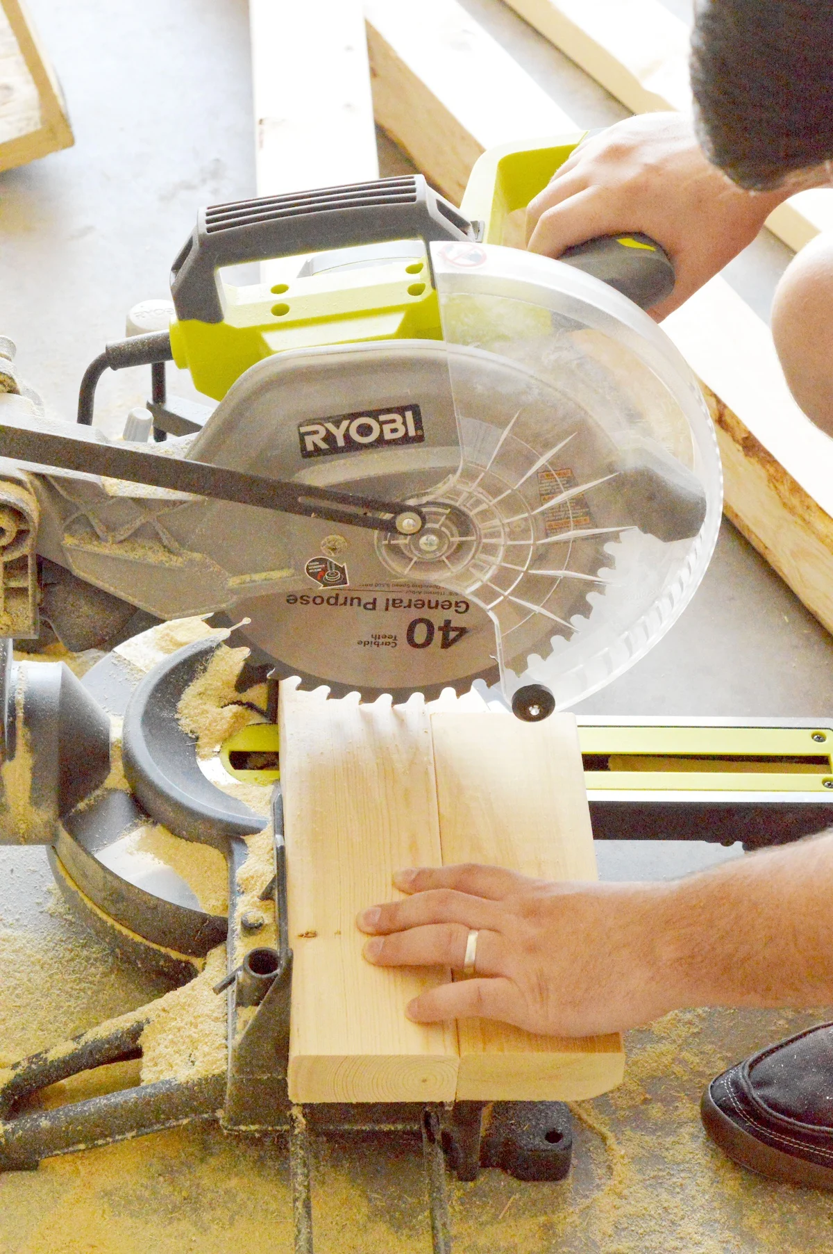 lowering the miter saw onto the wood