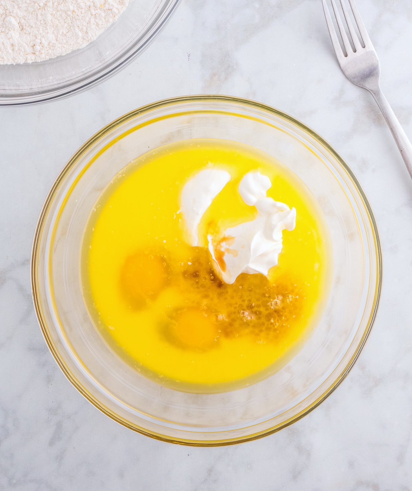 whisk together the melted butter, eggs, sour cream, milk, and vanilla extract