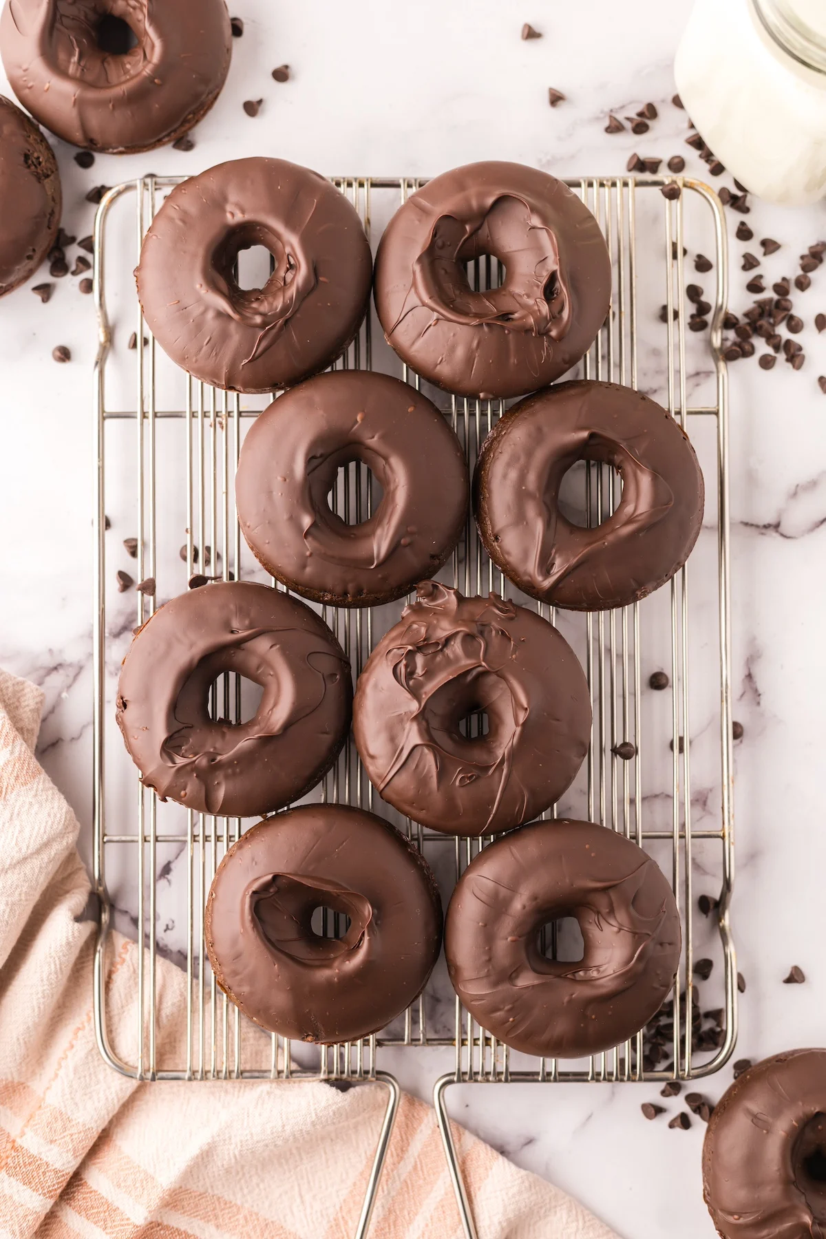 Baked donuts with chocolate frosting setting on a wire rack