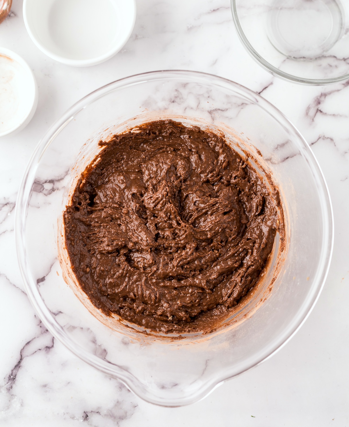 Flour, cocoa powder, sugar, and baking soda mixed with the wet ingredients in the bowl