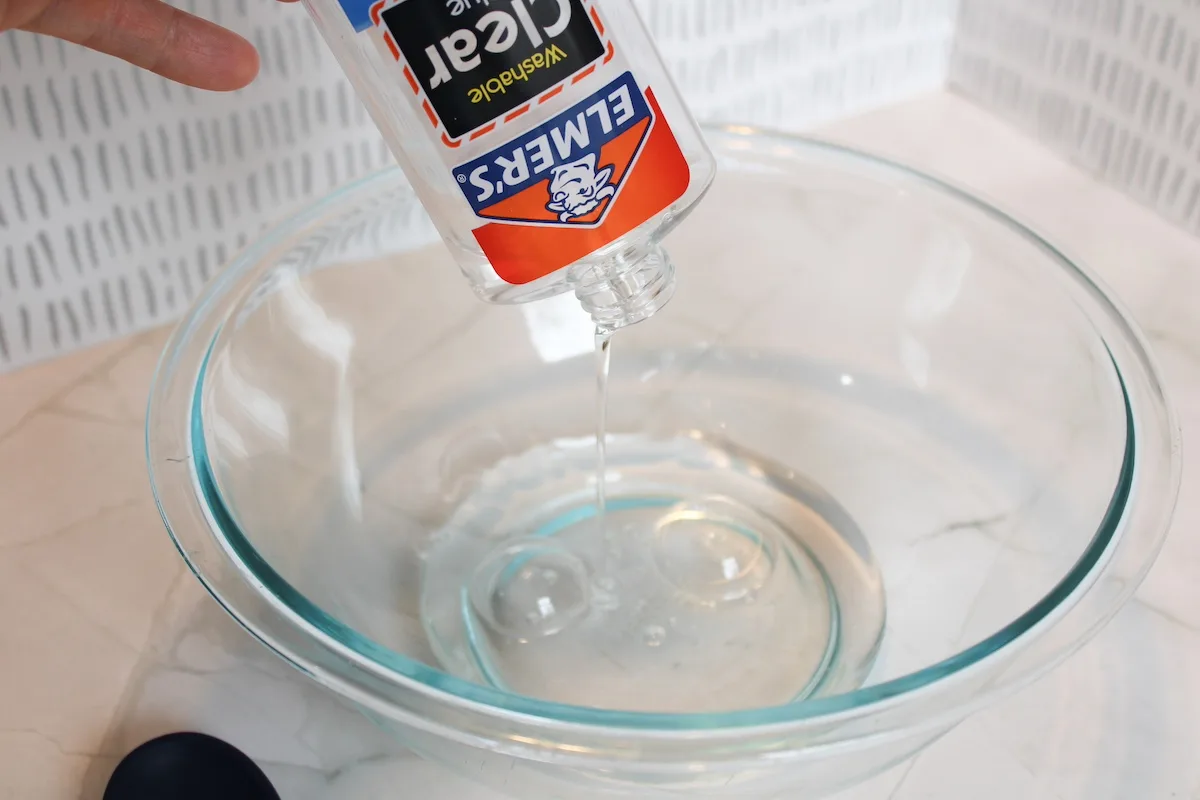 Adding a bottle of clear glue to a clear glass bowl