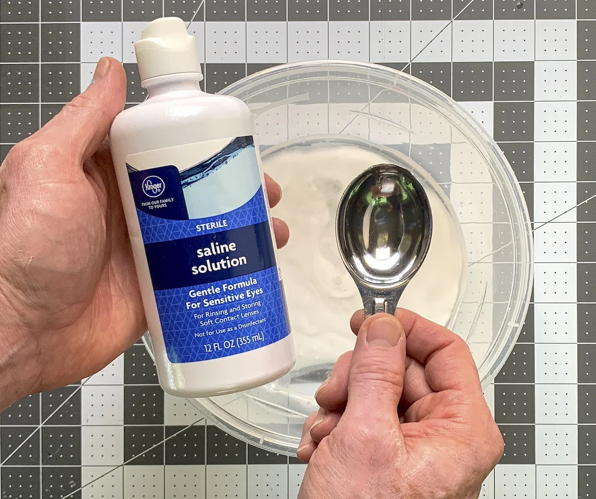 Adding contact lens solution to the water, glue, and baking soda mixture