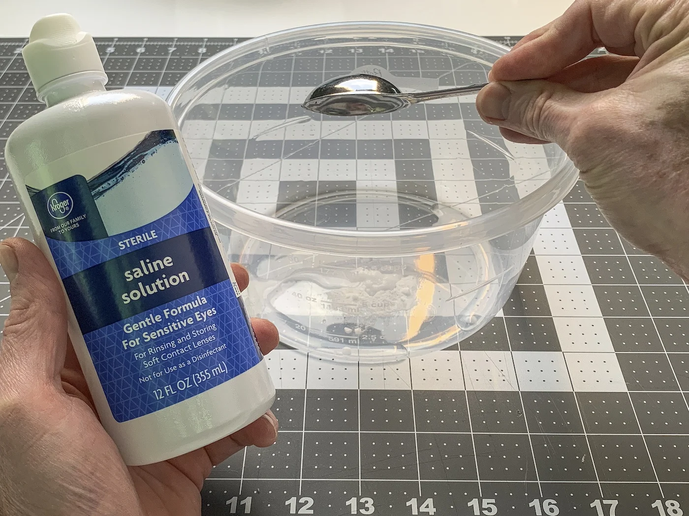 Adding the contact lens solution to the container