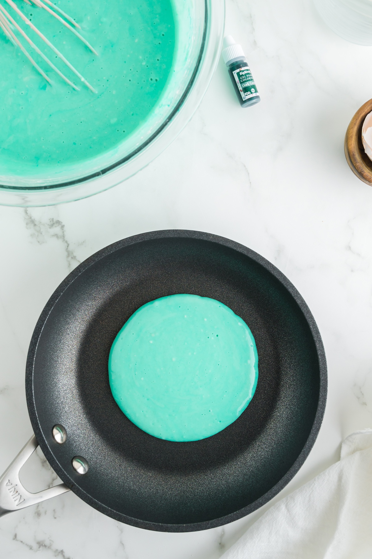 Green batter cooking in a pan