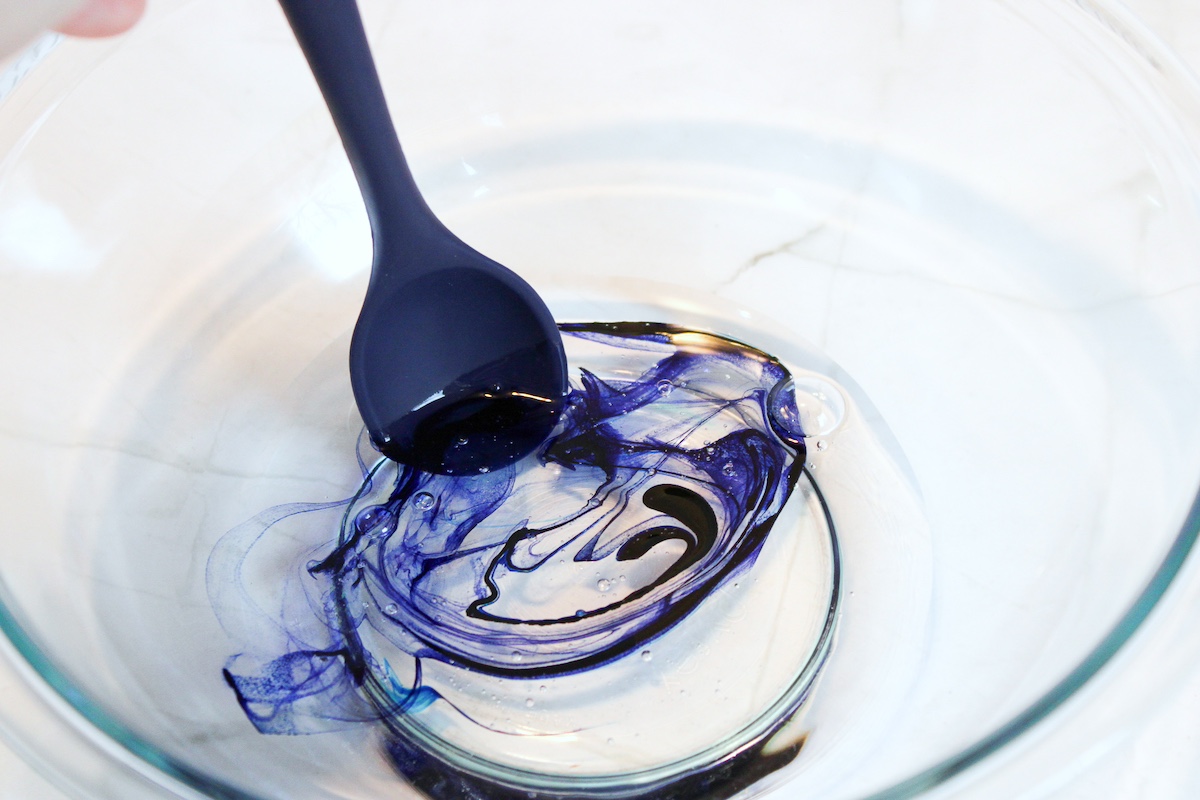 Stirring food coloring into clear glue