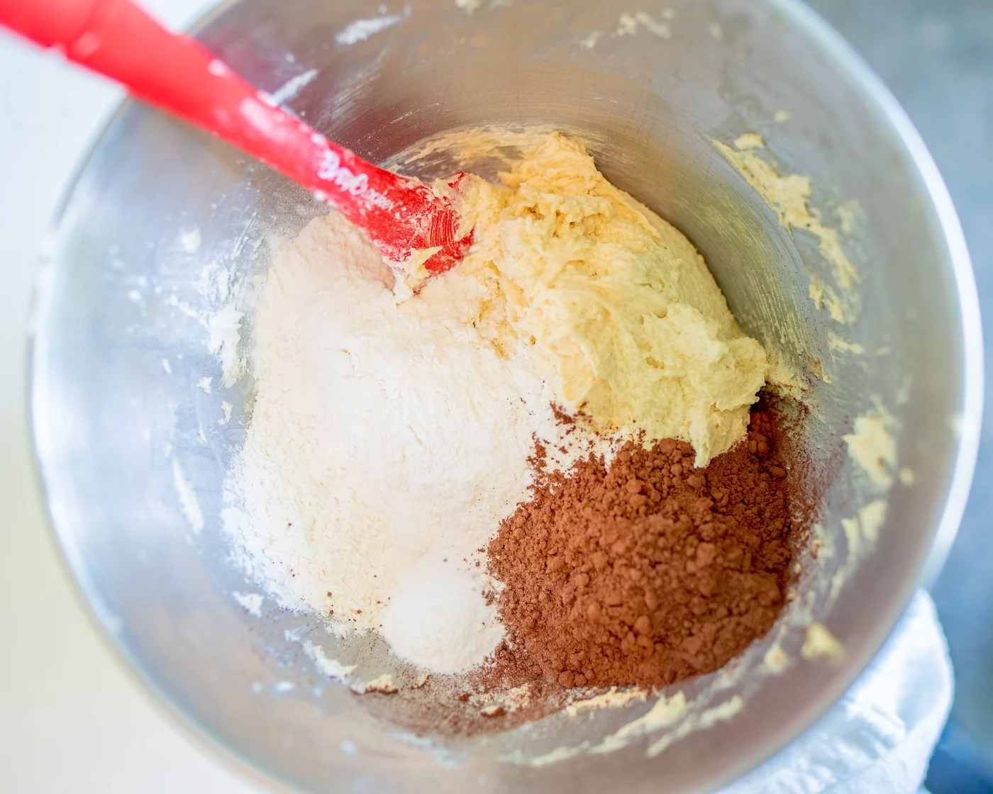 Dry ingredients added to the wet in a metal bowl