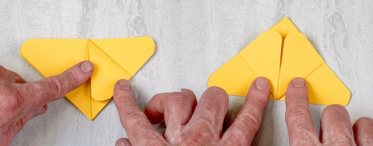 Fold the edges of the base of the triangle up against the center line