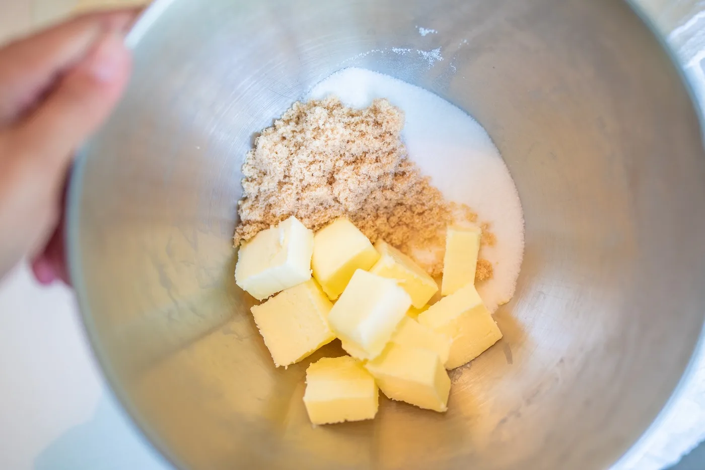 unsalted butter, brown sugar, and granulated sugar in a metal bowl