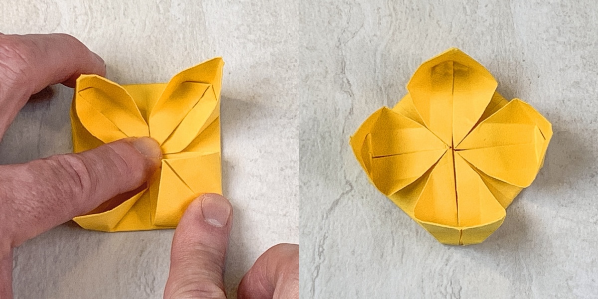 while holding the center down push in all four petals