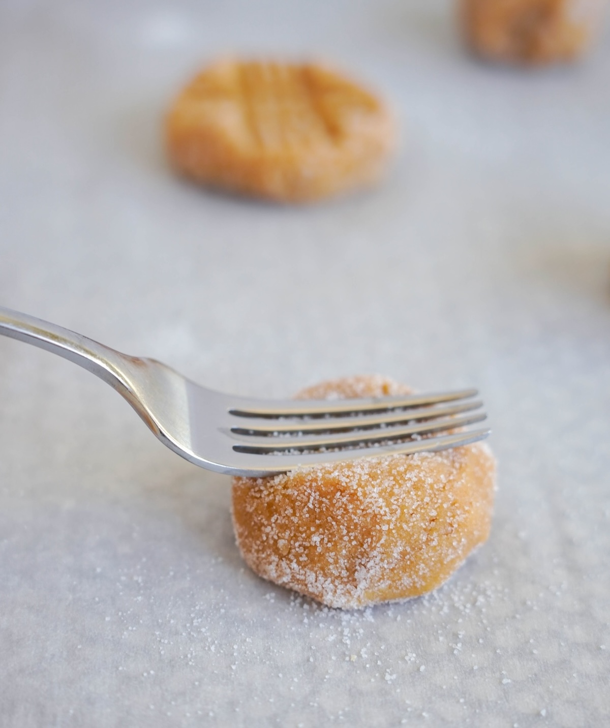 Fork pressing down onto the dough ball