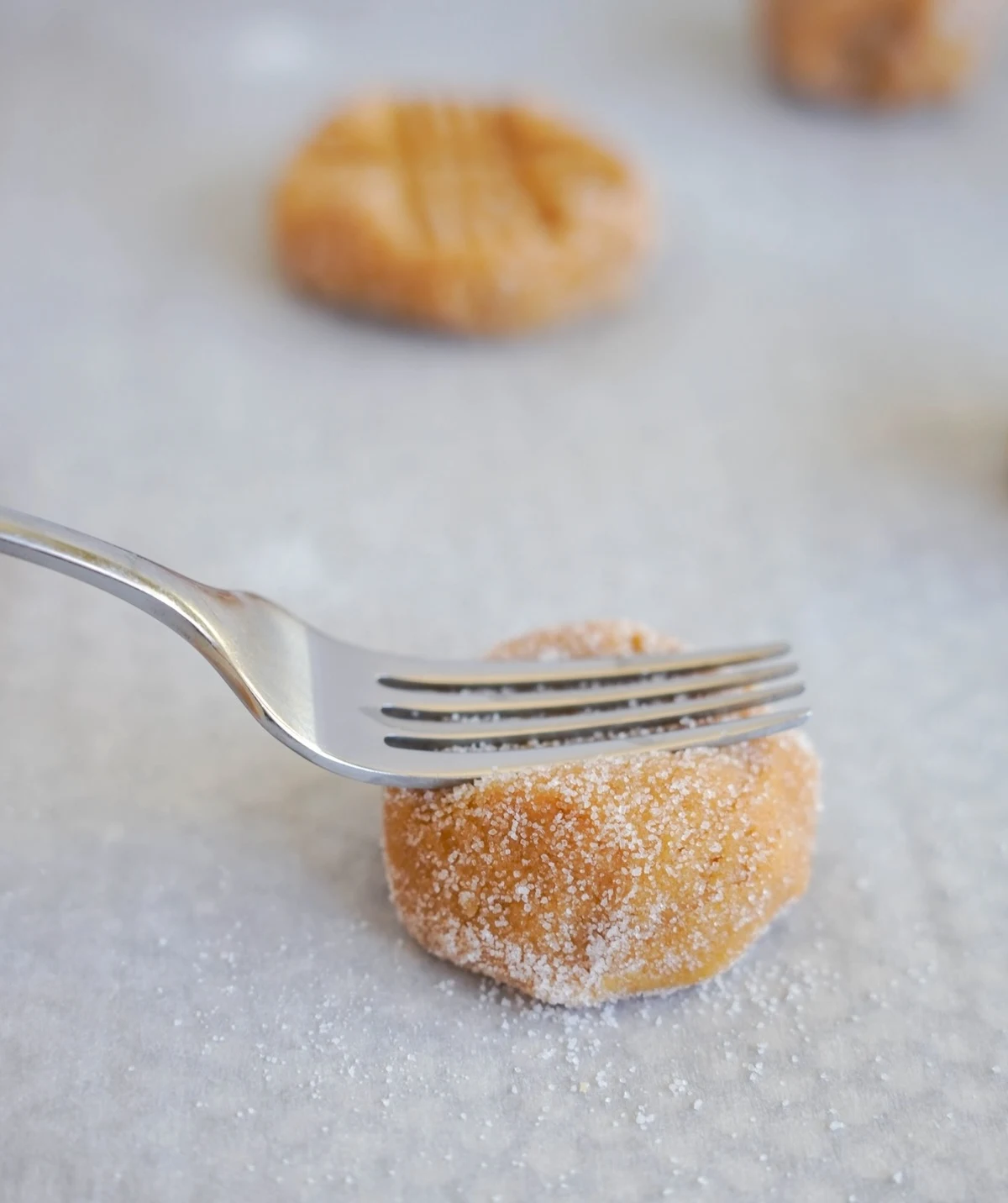 Fork pressing down onto the dough ball