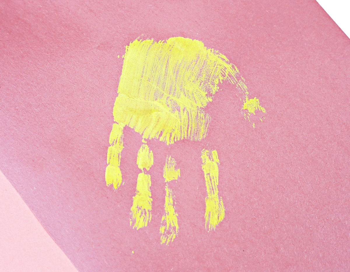 yellow handprint on pink paper