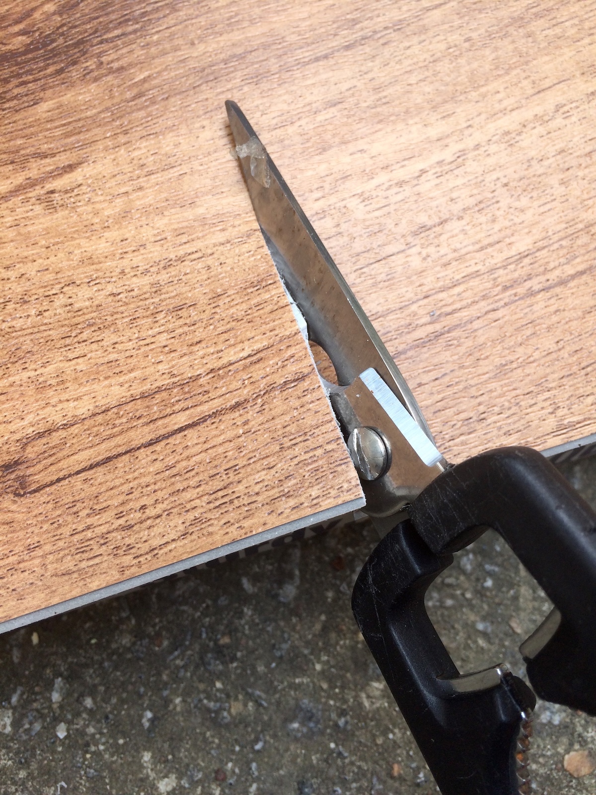 cutting vinyl flooring with utility scissors